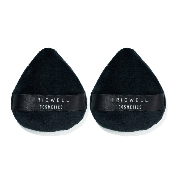 two mini powder puffs with brand name 'Trigwell Cosmetics' printed in white text on the black ribbon of the powder puff 