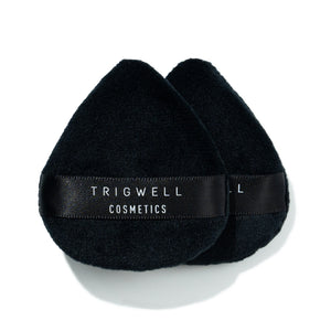 two mini powder puffs with brand name 'Trigwell Cosmetics' printed in white text on the black ribbon of the powder puff 