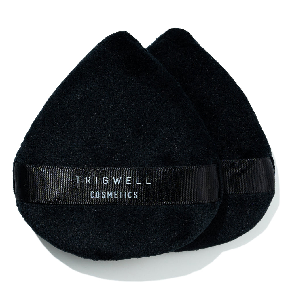 large powder puff with brand name 'Trigwell Cosmetics' printed in white text on the black ribbon of the powder puff 