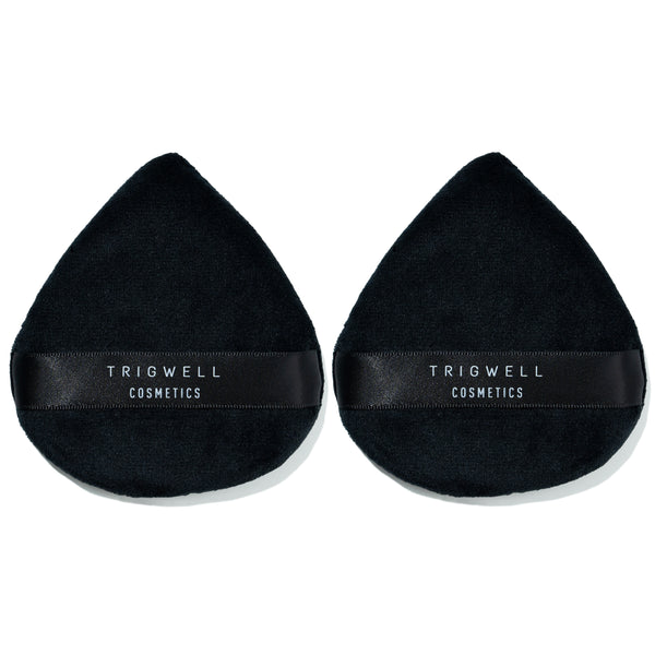 large powder puffs with brand name 'Trigwell Cosmetics' printed in white text on the black ribbon of the powder puff 